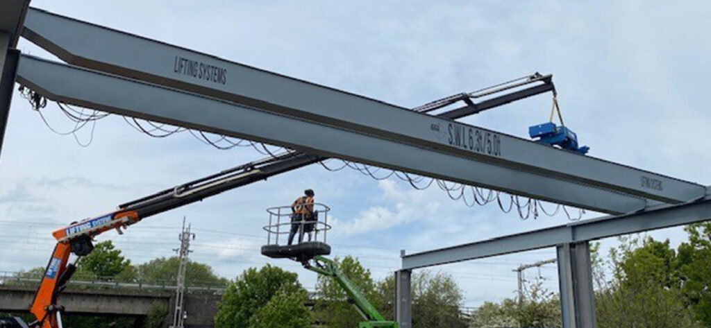 Overhead Crane installation with workers and equipment.